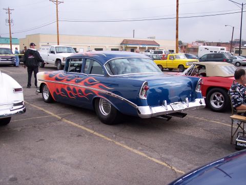 1972 Ford Ranchero - A blue 1955 Chevrolet sedan with flame decals is parked in a lot with other vehicles.