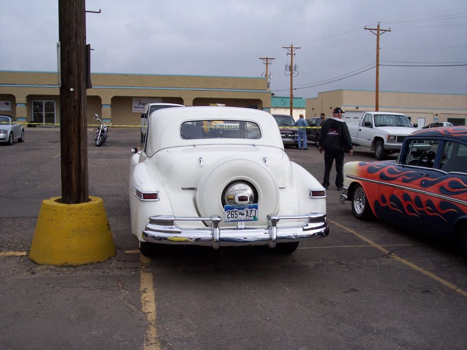 White convertible with spare tire on rear, license plate 265-AZJ