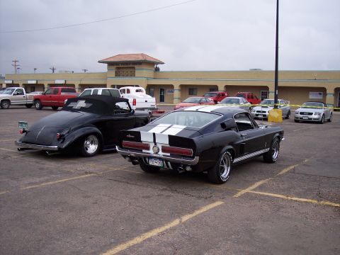 1972 Ford Ranchero - Rear view of a black 1967 Ford Mustang Shelby GT500 with white racing stripes.