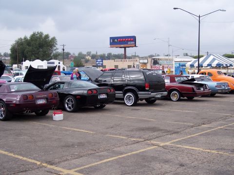 1972 Ford Ranchero - A variety of vehicles are parked in an outdoor lot under a cloudy sky.