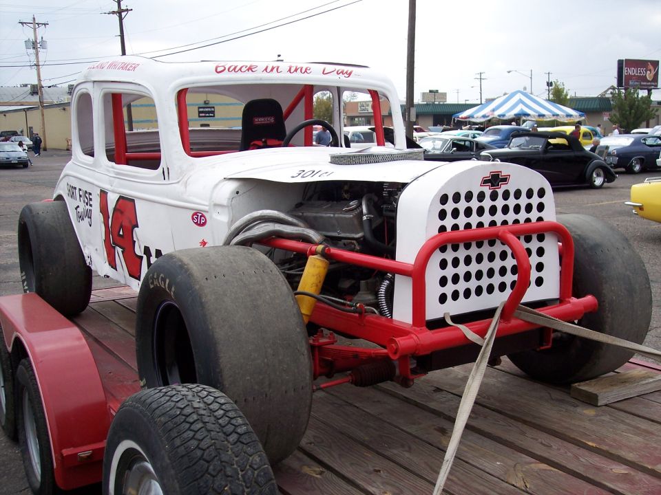 White modified race car with red roll cage and grille, on a trailer. Visible text includes 'Dirt Fuse Towing' and '14'
