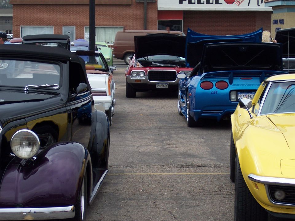 1972 Ford Ranchero parked next to a blue Corvette and a yellow Corvette