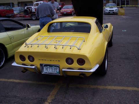 1972 Ford Ranchero - A yellow Corvette is parked in a lot, with its hood open, next to a yellow sports car.