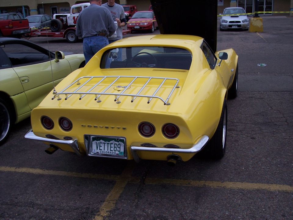 Yellow Corvette with luggage rack and license plate reading VETTE69