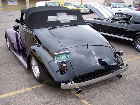 1972 Ford Ranchero - Black convertible with custom pinstriping and license plate COOL 37 is parked next to a black Mustang.