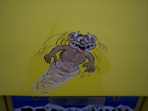 1972 Ford Ranchero - A cartoon monster is depicted in a tornado graphic on a yellow surface, possibly a vehicle.
