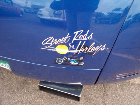 1972 Ford Ranchero - A blue vehicle displays a custom decal, with other vehicles reflected in its paint.