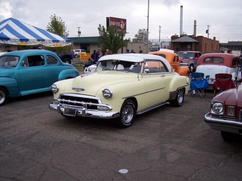 1972 Ford Ranchero - A pale yellow Chevrolet coupe is parked at an outdoor event with several other classic vehicles.