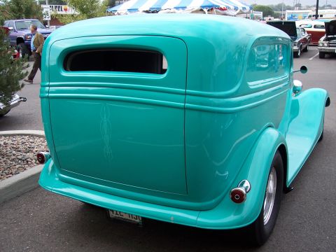 1972 Ford Ranchero - A teal panel van with custom pinstripes is parked at a car show.