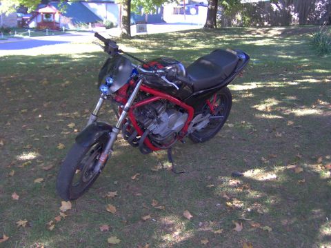 1993 Yamaha Seca II - A black and red motorcycle is parked on a grassy area with scattered leaves.