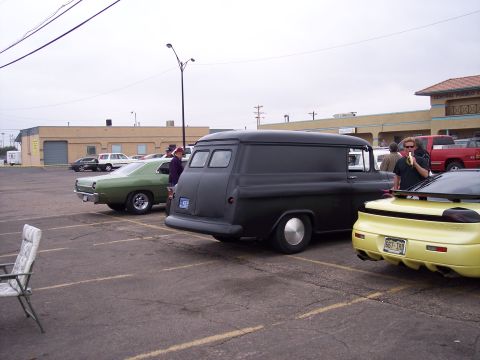 1972 Ford Ranchero - A black panel van is parked in a lot alongside other vehicles under an overcast sky.