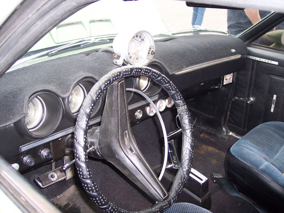 1972 Ford Ranchero interior with a black dashboard, a tachometer mounted on top, and a black steering wheel with silver studs