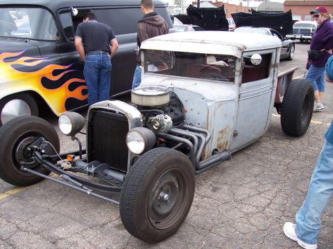 1972 Ford Ranchero - Hot rod pickup truck with custom exhaust and exposed engine, parked next to a vehicle with flame graphics.