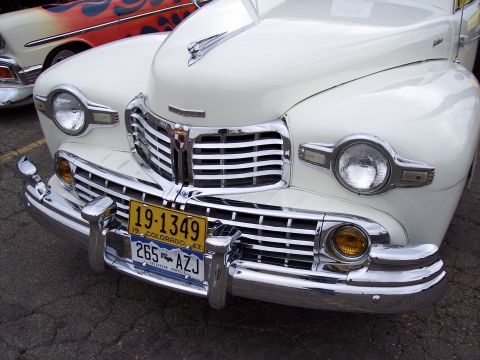 1972 Ford Ranchero - A white 1947 Lincoln Continental is parked next to another classic car with flames painted on its side.