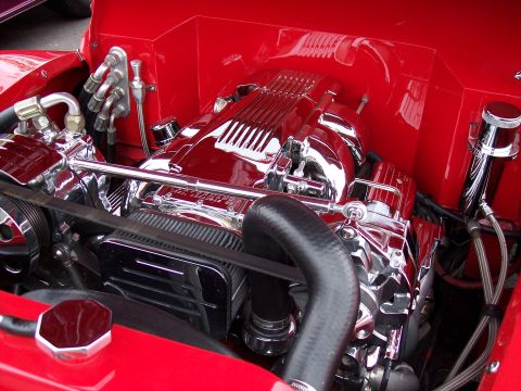 1972 Ford Ranchero - The engine bay is painted bright red, highlighting the polished chrome components of this V8 motor.