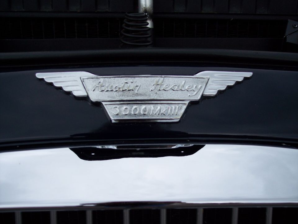 Chrome Austin Healey 3000MKIII badge on a dark car hood