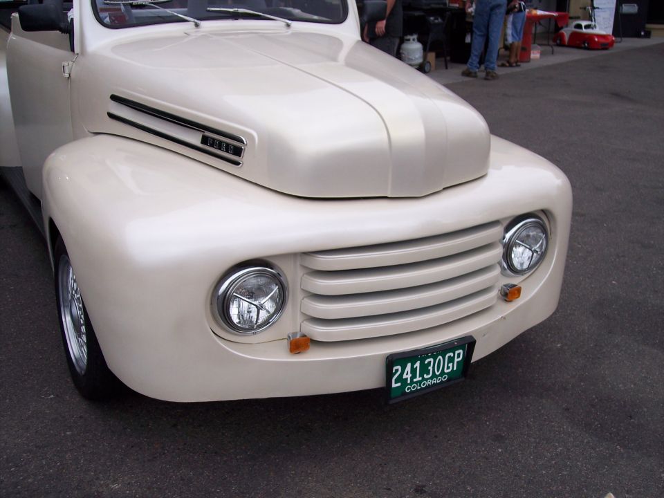 Cream-colored 1951 Ford F-Series truck front end with horizontal grille and round headlights. Colorado license plate reads 24130GP