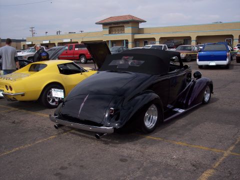 1972 Ford Ranchero - Black convertible hot rod and yellow Corvette at a car show.