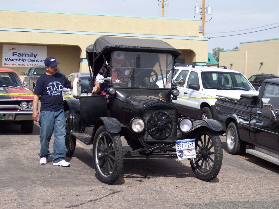 Black antique car with a black soft top, viewed from the front
