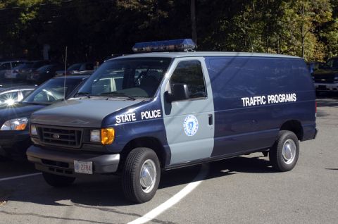 1973 Dodge 1500 - A blue and gray Ford E-Series van, marked "STATE POLICE" and "TRAFFIC PROGRAMS", is parked outdoors.