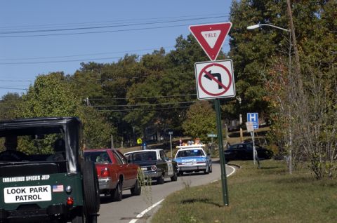 1973 Dodge 1500 - A Jeep marked for park patrol is seen in traffic behind other vehicles, including police cars.