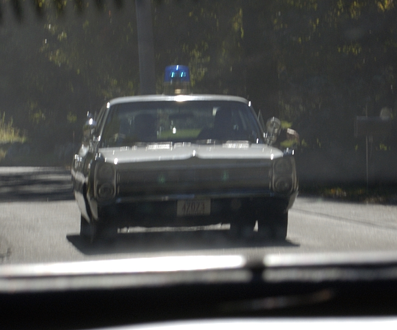 Front view of a 1973 police car with a blue light on the roof and license plate 47071