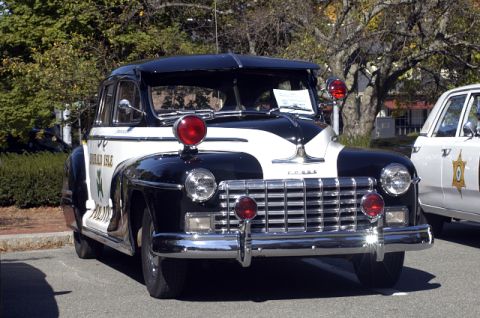 1973 Dodge 1500 - Vintage black and white police car, likely from the late 1940s, parked next to another vehicle.