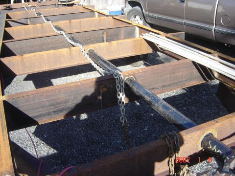 1993 Ford Bronco - A trailer frame is shown with chains, and a brown pickup truck is visible in the background.