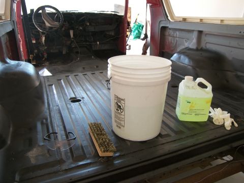 1978 Ford Bronco - The interior of a vehicle is shown with cleaning supplies, indicating preparation for painting.