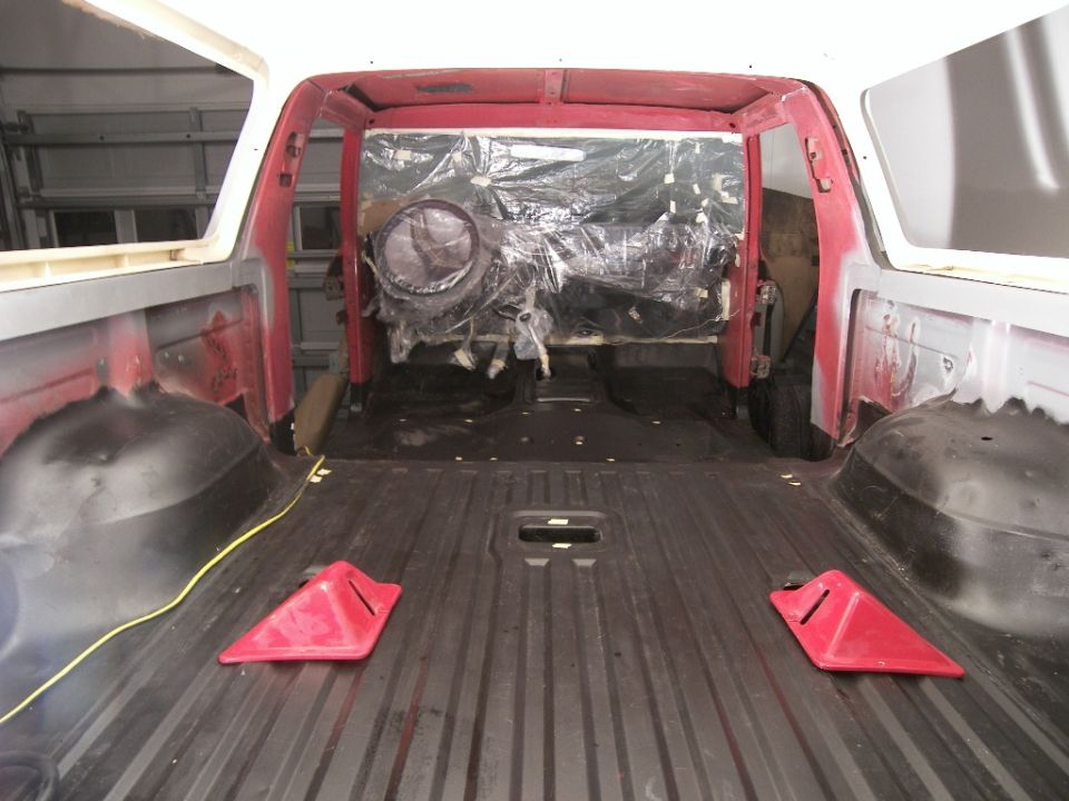 Interior of a vehicle under construction, showing exposed metal and plastic-covered components