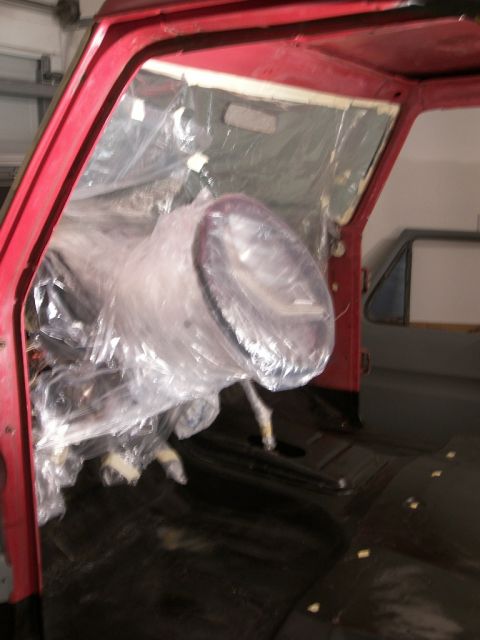 1978 Ford Bronco - Vehicle interior covered in plastic sheeting, likely during a restoration or painting process.