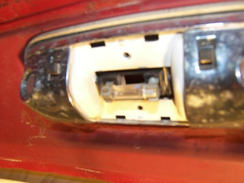 1978 Ford Bronco - Close-up of a vehicle's interior dome light assembly, showing its internal components and chrome trim.