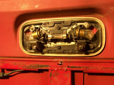 1978 Ford Bronco - Close-up of a vehicle's dome light assembly, showing bulbs, fuse, and Ford branding.