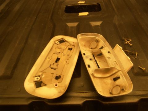 1978 Ford Bronco - Disassembled dome light housing and screws are shown on a dark textured surface.