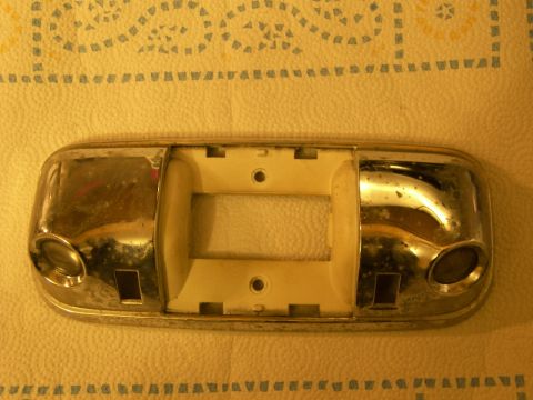 1978 Ford Bronco - A chrome and white dome light assembly is shown, likely removed from a vehicle's interior.