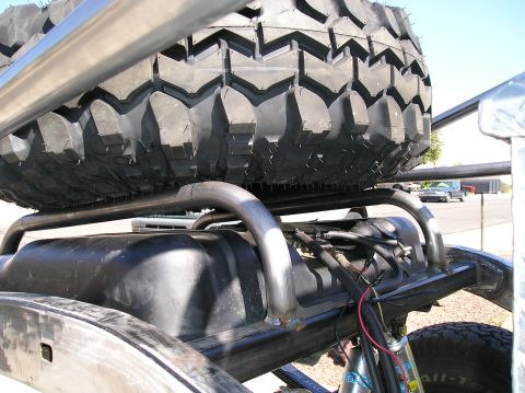 1986 Toyota Hilux - A large spare tire is secured above a fuel tank, part of a custom vehicle build.
