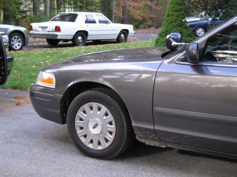 1991 Ford LTD Crown Victoria - A gray Ford Crown Victoria is parked in front of a white Ford Crown Victoria.