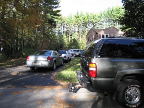 1991 Ford LTD Crown Victoria - A dark SUV is parked in a driveway, with several other cars lined up behind it.