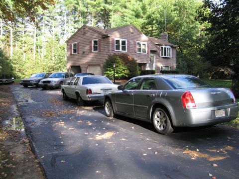 1991 Ford LTD Crown Victoria - Multiple vehicles are parked in a residential driveway on an autumn day.