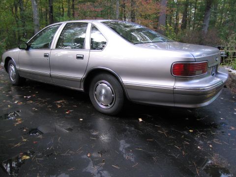 1991 Ford LTD Crown Victoria - This 1991 Ford Crown Victoria LTD is viewed from the rear three-quarter angle on a wet driveway.