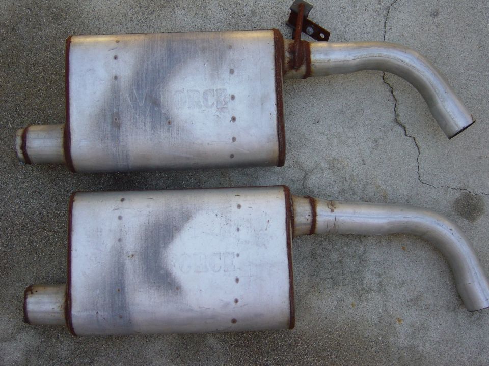 Pair of oval mufflers with bent tailpipes on concrete, embossed FORCE branding