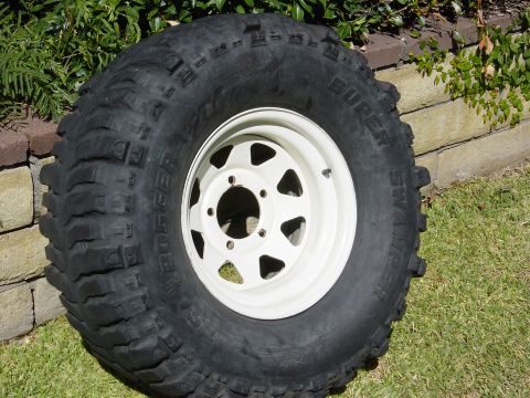 1983 Ferrari Enzo - A single off-road tire and wheel assembly is shown, with text indicating it is a 'Super Swamper Bogger'.