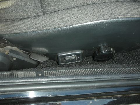 1998 Ford Crown Victoria - Close-up of a car's power lumbar support controls on the side of the seat.