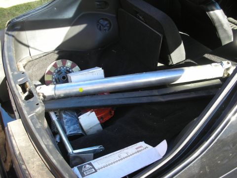 1998 Ford Crown Victoria - The trunk of a vehicle contains a driveshaft, a clutch assembly, and several boxes of parts.