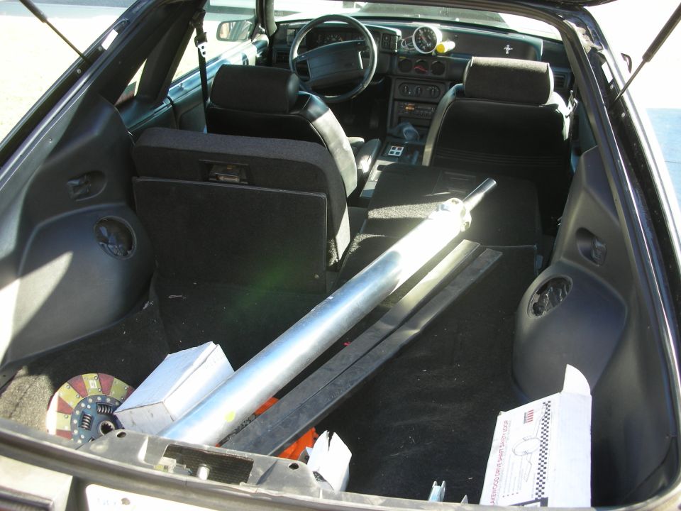 Hatchback interior viewed from rear with seats folded and a metal bar