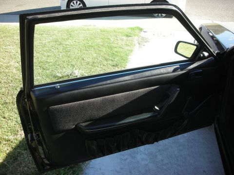1998 Ford Crown Victoria - View of a car's interior door panel and window, with another vehicle partially visible outside.