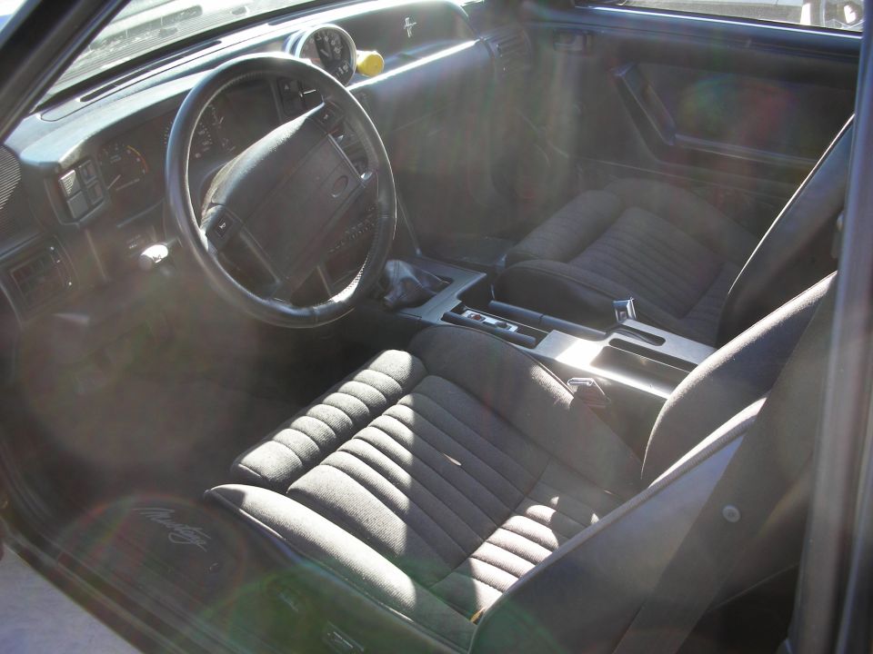 Front interior of a Mustang with gray cloth seats and console