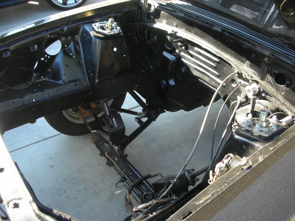 Empty engine bay with exposed strut towers and steering rack