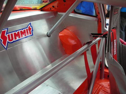 1998 Ford Crown Victoria - The interior of a race car features aluminum paneling and a prominent Summit sticker.