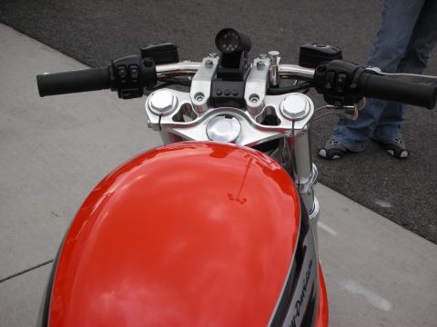 1998 Ford Crown Victoria - Close-up view of a red motorcycle's fuel tank and handlebars, a mounted camera and chrome accents.